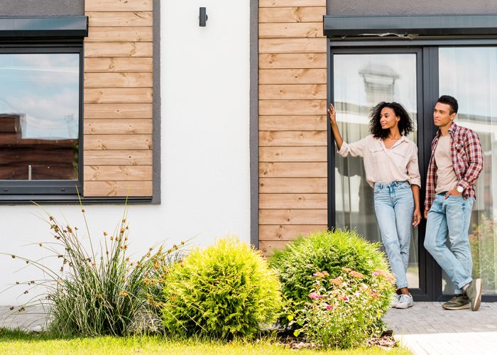 panoramic shot of african american man and woman standing outsid panoramic shot of african american man and woman standing outside near house
